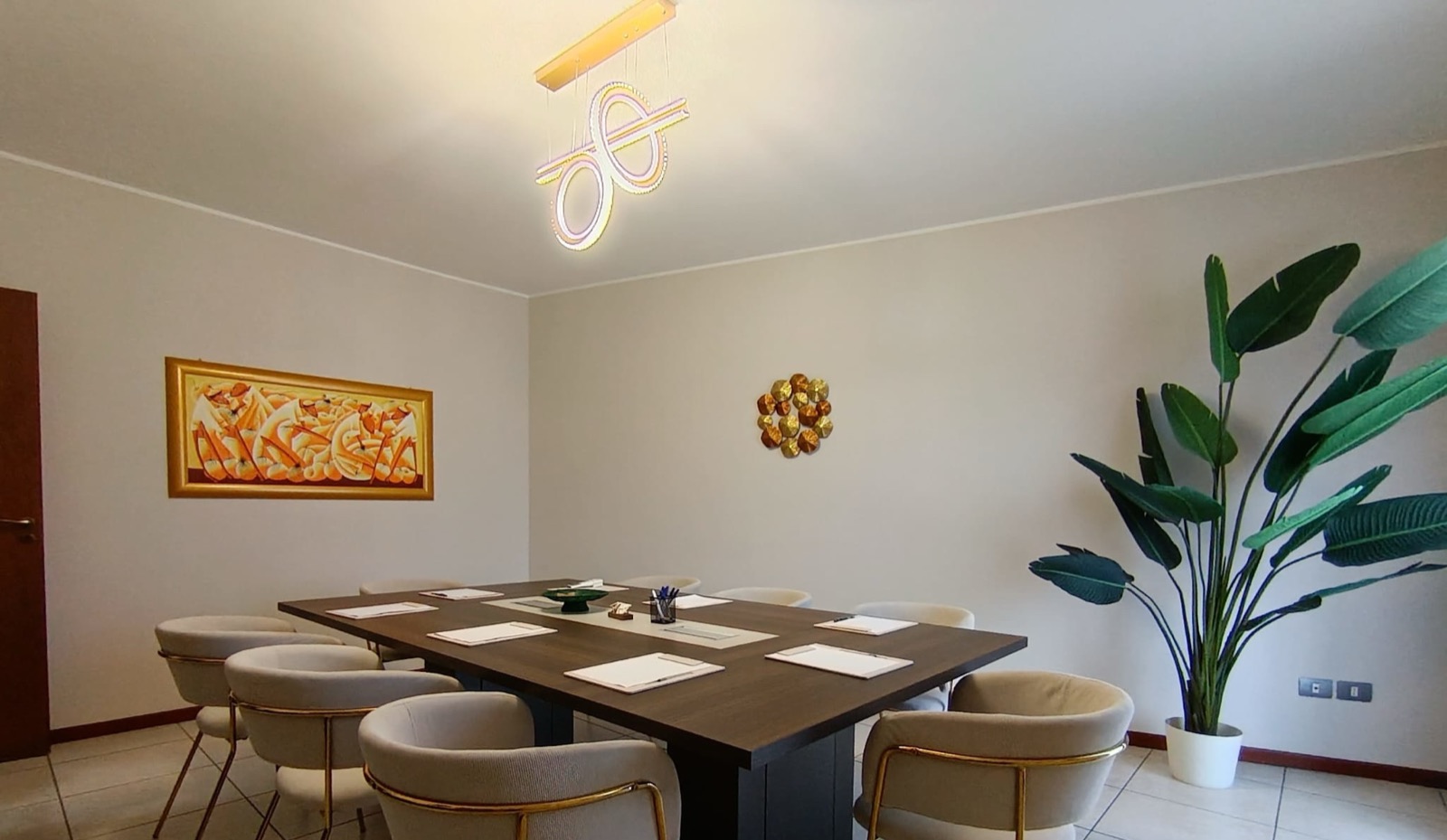Sala riunioni con tavolo da otto posti e sedie imbottite